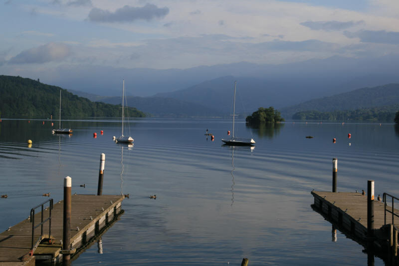 Lake Windermere during a tranquil Lake District cruise Calm morning on Lake Windermere with sailing boats and Lake District fells in the distance