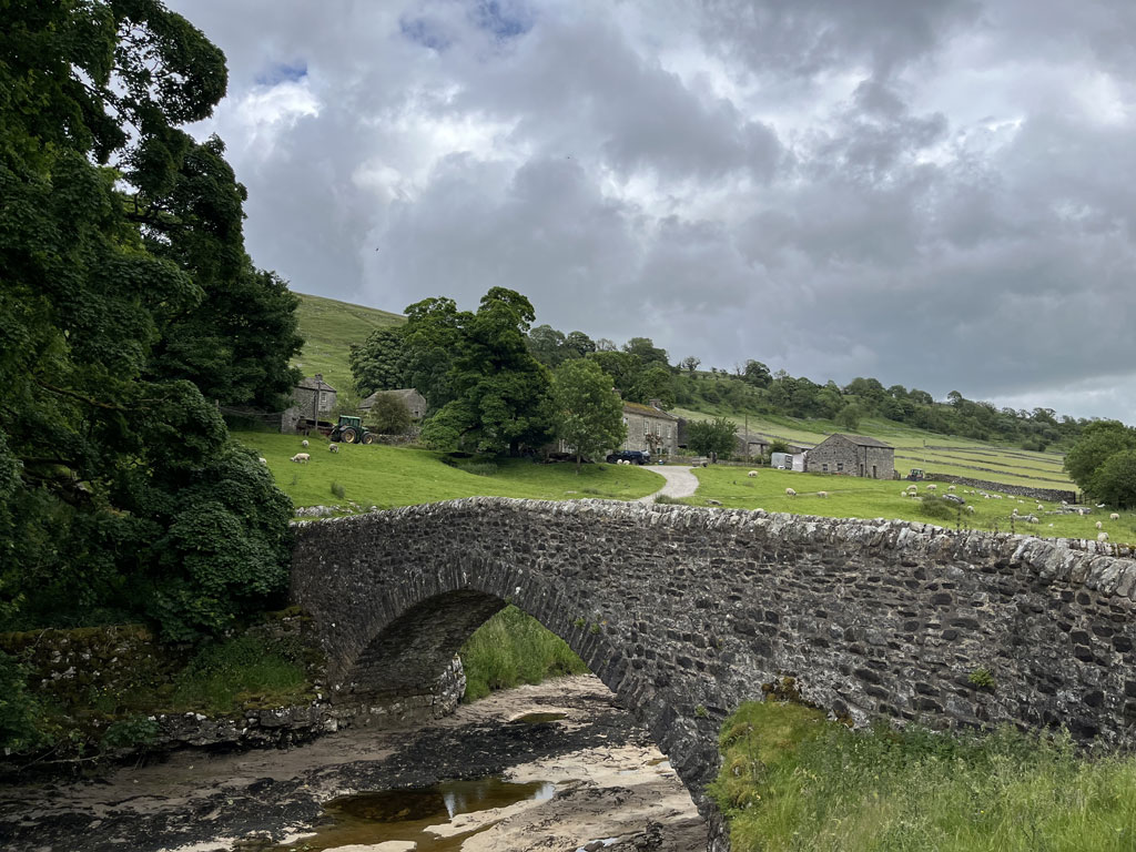 Stone bridge over stream in picturesque Yorkshire village.